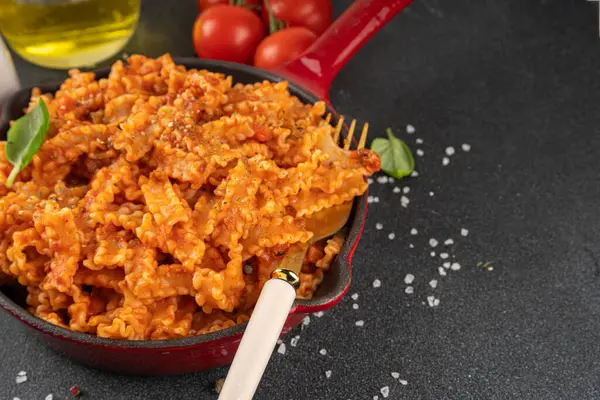 Domates soslu Mafaldine makarnası, İtalyan bolonezi, domates soslu marinara, vegan mantarı ya da siyah beton arka planda patlıcan soslu makarna, malzemeler ve baharatlar, kopyalama alanı.