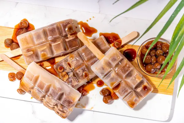 Tapioka latte buzlu şeker. Donmuş tapyoka boba topları kahve frappe, Asya usulü soğuk tapyoka kahvesi, Hindistan cevizi kremalı ve karamel soslu lolipoplar.