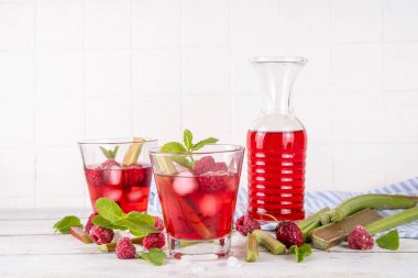 Ahubarb üzümlü buzlu çay, limonata ya da mojito. Soğuk yaz meyveli içecek. Beyaz ahşap masa üzerinde ravent şurubu, ahududu ve nane ile. 