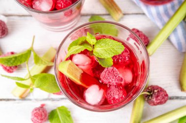 Ahubarb üzümlü buzlu çay, limonata ya da mojito. Soğuk yaz meyveli içecek. Beyaz ahşap masa üzerinde ravent şurubu, ahududu ve nane ile. 