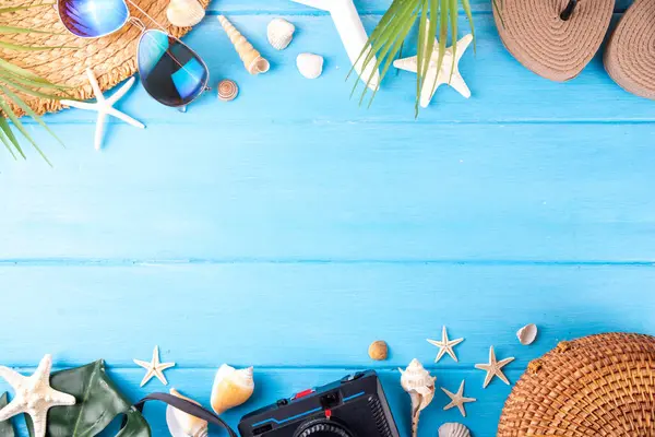 Yaz tatili ve hasır şapkalı, çantalı, terlikli, palmiye yapraklı, güneş gözlüklü, kameralı, deniz kabuklu ve okyanus yıldızlı tatil geçmişi. Plaj ve tropikal yaz tatili arka planı, üst görünüm kopyalama alanı