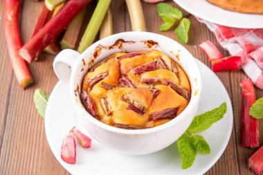 Yaz ev yapımı pişirme, hızlı mikrodalga fırın kek, mugcake. Basit tatlı mevsimlik tatlı tarifi, üstünde ravent dilimleri ve içinde tatlı reçel olan sünger keki.