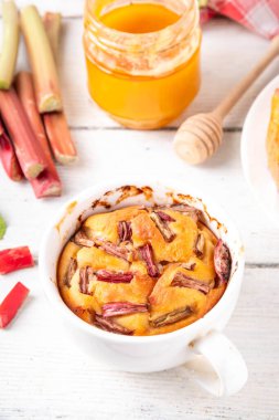 Yaz ev yapımı pişirme, hızlı mikrodalga fırın kek, mugcake. Basit tatlı mevsimlik tatlı tarifi, üstünde ravent dilimleri ve içinde tatlı reçel olan sünger keki.