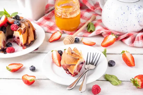 Taze meyve ve böğürtlenli yaz pastası. Geleneksel yuvarlak sünger keki, çilekli mevsimlik tatlı, ahududu, yabanmersini, bal ve şeker serpintileri, beyaz ahşap masa fotokopisi alanı