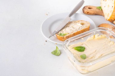 Ev yapımı vegan yağı, sütsüz krema, soya fasulyesi izinli alternatif tereyağı ve mutfak masasının arkasında ev yapımı ekmek.
