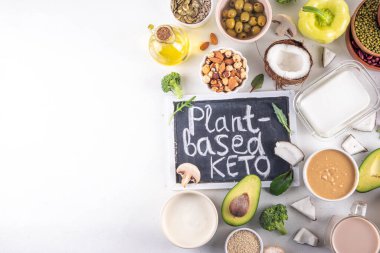 Bitki bazlı keto gıda arka planı, düşük karbonhidratlı vejetaryen keto diyet malzemeleri, sağlıklı vejetaryen yağ ve protein kaynağı. Çeşit çeşit yeşil sebzeler, fındık, baklagiller, yağ, hindistan cevizi, fıstık, fıstık ezmesi