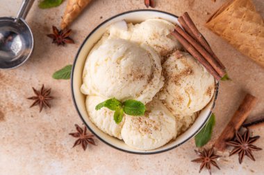 Hindistan 'da soğuk yaz Garam Masala Gelato tatlısı, Hindistan' da üç baharatlı dondurma, beyaz seramik kasede, nane yaprakları, baharatlar ve kremalı dondurma külahları.