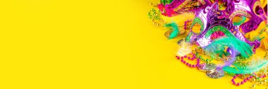 Mardi Gras renkli bayram tebrik kartı arkaplanı festival maskesi, dekor, karnaval maskesi, boncuklar, tüyler, parlak arka plandaki fanlar geleneksel mor yeşil renkler