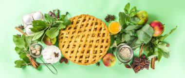  Sonbaharda elmalı turtayla pişirme arka planı. Geleneksel Amerikan elmalı turtası taze elmalar, tarçın, baharatlar, fırın malzemeleri, açık yeşil arka planda üst görünüm kopyalama alanı