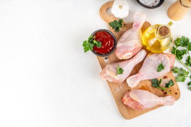 Tavuk eti hazırlama arka planı, ızgaraya hazır çiğ tavuk bacağı, baharatlar, tuz, biber, zeytinyağı, sarımsak ve salamura veya sos. Izgara ve bbq sezon pişirme arka planı, kopyalama alanı