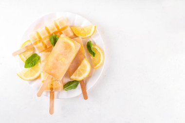 Buzlu çay veya limonata, tatlı limon ve naneli kokteyl lolipopları soğuk içecek, limon dilimleri ve nane yaprakları fotokopi alanı