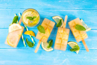 Buzlu çay veya limonata, tatlı limon ve naneli kokteyl lolipopları soğuk içecek, limon dilimleri ve nane yaprakları fotokopi alanı