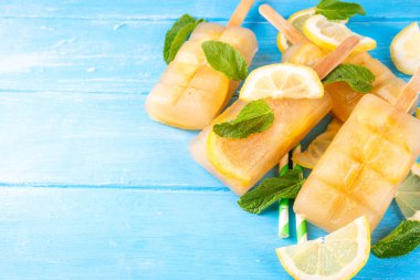 Buzlu çay veya limonata, tatlı limon ve naneli kokteyl lolipopları soğuk içecek, limon dilimleri ve nane yaprakları fotokopi alanı