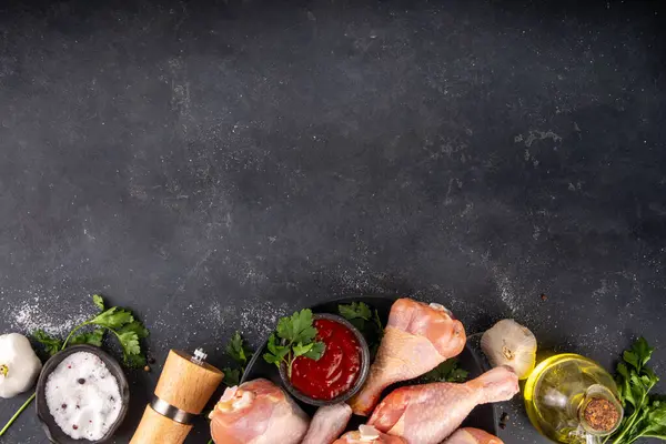 Tavuk eti hazırlama arka planı, ızgaraya hazır çiğ tavuk bacağı, baharatlar, tuz, biber, zeytinyağı, sarımsak ve salamura veya sos. Izgara ve bbq sezon pişirme arka planı, kopyalama alanı