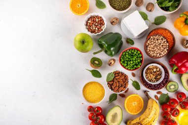 Portföy diyeti, fındık, sebze proteini, bitki sterolleri, yapışkan lif, fasulye, baklagiller, taze sebzeler ve beyaz arka plandaki meyveler dahil olmak üzere dengeli kolesterol vejetaryen gıdalar.