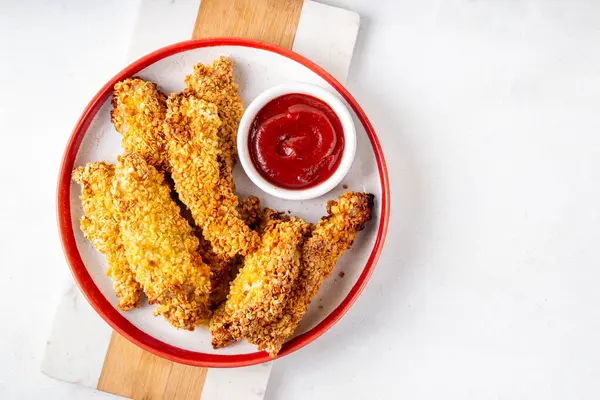 Lezzetli, taze pişmiş tavuk nugget ya da şeritli, altın mısır ekmekli, daha az yağda kızartılmış. Ev yapımı dengeli diyet fast food alternatifi