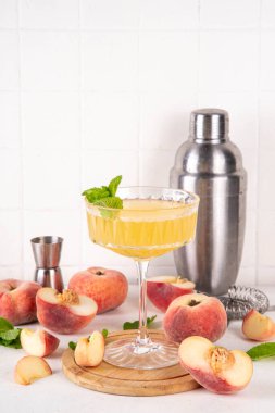 Düz şeftalili martini ya da margarita limonata soğuk meyve suyu, nane ve limonlu yaz meyve suyu kokteyli, beyaz masada.