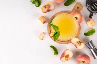 Düz şeftalili martini ya da margarita limonata soğuk meyve suyu, nane ve limonlu yaz meyve suyu kokteyli, beyaz masada.