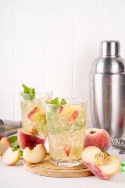Düz şeftalili limonata, buzlu çay ya da taze meyve garnitürlü mojito kokteyli. Alkolsüz, yassı Çin çöreği incir şeftali, şeftali dilimleri, nane ve ezilmiş buz.