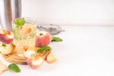 Düz şeftalili limonata, buzlu çay ya da taze meyve garnitürlü mojito kokteyli. Alkolsüz, yassı Çin çöreği incir şeftali, şeftali dilimleri, nane ve ezilmiş buz.