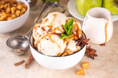 Ev yapımı elmalı turtalı dondurma. Bir kase geleneksel elmalı turta ya da elmalı turta, karamelli elma, bisküvi, karamel sosu, tarçın ve baharatlı.