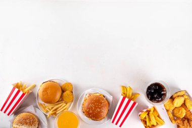 Fast food servis menüsünde çeşitli hamburgerler, cheeseburger, nugget, patates kızartması, gazlı içecek. Ivır zıvır sağlıksız fast food, düşük besinli Ultra işlenmiş gıda, yüksek kalori değeri