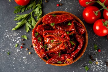 Zeytin yağında ev yapımı kurutulmuş domatesler, gurme İtalyan yemekleri, taze domates, yağ şişesi ve mutfak masasında baharatlar.