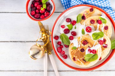 Kış kahvaltısı ya da brunch için yaban mersinli krep. Noel kutlaması, yeni yıl kahvaltısı vanilyalı kremalı tatlı ve taze kızılcık, kopyalama alanı.