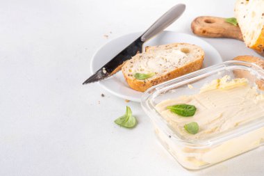 Ev yapımı vegan yağı, sütsüz krema, soya fasulyesi izinli alternatif tereyağı ve mutfak masasının arkasında ev yapımı ekmek.