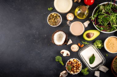 Bitki bazlı keto gıda arka planı, düşük karbonhidratlı vejetaryen keto diyet malzemeleri, sağlıklı vejetaryen yağ ve protein kaynağı. Çeşit çeşit yeşil sebzeler, fındık, baklagiller, yağ, hindistan cevizi, fıstık, fıstık ezmesi
