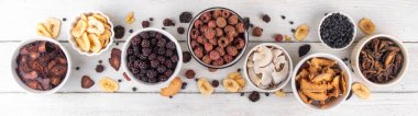 Dondurulmuş meyveler, yaz hasadını depolamak için alternatif bir yol. Kurumuş kurutulmuş ahududu, yabanmersini, şeftali, muz, kayısı, erik, böğürtlen, elma, beyaz ahşap arka planda kiraz.