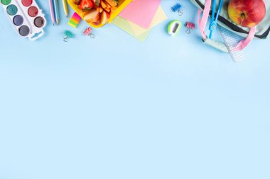 Okula dönelim. Sağlıklı okul yemekleri, çocuklar beslenme çantasına meyve, böğürtlen, fındık ve sebzeli sandviç koydu. Çocukların diyet yemekleri, eğitim okulu malzemeleri, parlak mavi arka plan manzarası.