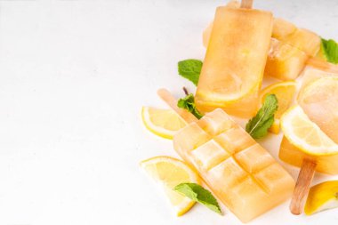 Buzlu çay veya limonata, tatlı limon ve naneli kokteyl lolipopları soğuk içecek, limon dilimleri ve nane yaprakları fotokopi alanı