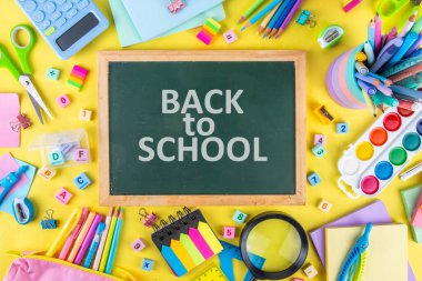 Okulun çeşitli okul gereçleri, öğrenciler ve okul çocukları için eğitim aksesuarları, defterler, kalemler, kalemler, hesap makinesi, kalem kutusu, sırt çantası, kulaklık içeren renkli geçmişine geri dön