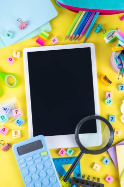 Okulun çeşitli okul gereçleri, öğrenciler ve okul çocukları için eğitim aksesuarları, defterler, kalemler, kalemler, hesap makinesi, kalem kutusu, sırt çantası, kulaklık içeren renkli geçmişine geri dön