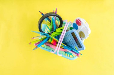 Okulun çeşitli okul gereçleri, öğrenciler ve okul çocukları için eğitim aksesuarları, defterler, kalemler, kalemler, hesap makinesi, kalem kutusu, sırt çantası, kulaklık içeren renkli geçmişine geri dön