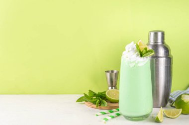 Limonlu turta ya da mojito soğuk milkshake kokteyli. Krem şantili, naneli ve limonlu tatlı ekşi kremalı içecek, beyaz ve yeşil limonlu parlak arka plan. 