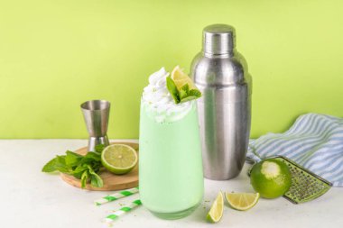 Limonlu turta ya da mojito soğuk milkshake kokteyli. Krem şantili, naneli ve limonlu tatlı ekşi kremalı içecek, beyaz ve yeşil limonlu parlak arka plan. 