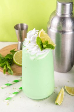 Limonlu turta ya da mojito soğuk milkshake kokteyli. Krem şantili, naneli ve limonlu tatlı ekşi kremalı içecek, beyaz ve yeşil limonlu parlak arka plan. 