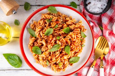 Bolonez soslu Fusilli makarna, kıyma, mantar, domates ve fesleğen. Geleneksel İtalyan yemek tabağı, masada servis edilen baharatlar.