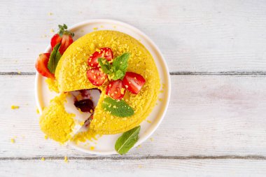 Tepetaklak Pasta yok, klasik Cheesecake New York 'un viral modası altın kurabiye parçacıkları, beyaz krem peynir ve böğürtlen reçeli katmanları, taze çilek ve ahşap masa üzerinde nane