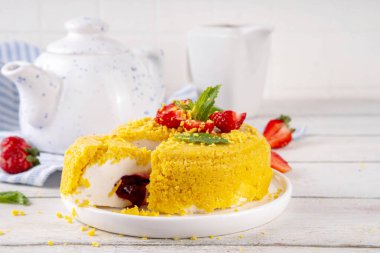 Tepetaklak Pasta yok, klasik Cheesecake New York 'un viral modası altın kurabiye parçacıkları, beyaz krem peynir ve böğürtlen reçeli katmanları, taze çilek ve ahşap masa üzerinde nane