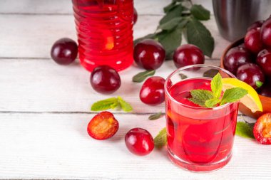 Yaz buzlu içecek, vişneli limonata veya sürahi ve bardakta mojito kokteyli, beyaz ahşap arka planda, kopyalama alanı.