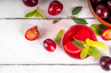 Yaz buzlu içecek, vişneli limonata veya sürahi ve bardakta mojito kokteyli, beyaz ahşap arka planda, kopyalama alanı.