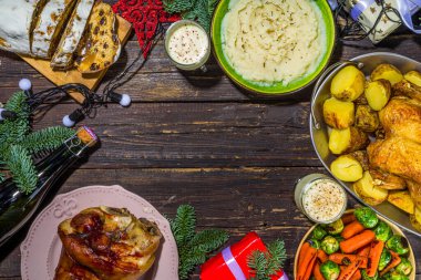 Geleneksel yemekli Noel yemeği masası ve fırında jambon, tavuk, kızarmış havuç ve brussel lahanası, patates, Noel süslemesi ve hediyeler. 