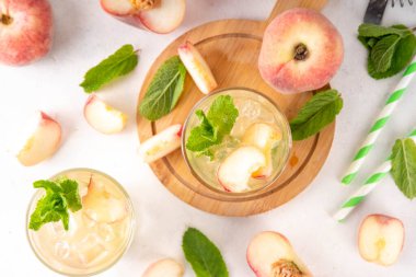 Düz şeftalili limonata, buzlu çay ya da taze meyve garnitürlü mojito kokteyli. Alkolsüz, yassı Çin çöreği incir şeftali, şeftali dilimleri, nane ve ezilmiş buz.