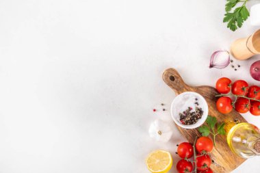Baharatlar, karabiber, sarımsak, soğan, yeşillik ve domates, beyaz yemek masasında zeytin yağı. Beyaz taş arkaplanda yemek pişirmek için gerekli malzemeler..