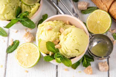 Yaz ferahlatıcı soğuk tatlı, lezzetli aromatik mojito veya limonlu turtalı dondurma, seramik kasede mojito kokteyli aromalı ev yapımı şerbet, taze limon, nane, ahşap zemin üzerinde waffle konileri.