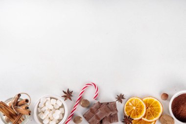 Sıcak çikolata yapmak için gerekli malzemeler, geleneksel kış kakaosu lezzetli içecekler. Çikolata parçaları, kakao tozu, süt, marşmelov, baharatlar, tarçın, fındık, kurutulmuş portakal, üst görünüm kopya alanı