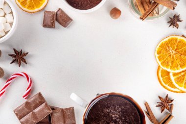 Sıcak çikolata yapmak için gerekli malzemeler, geleneksel kış kakaosu lezzetli içecekler. Çikolata parçaları, kakao tozu, süt, marşmelov, baharatlar, tarçın, fındık, kurutulmuş portakal, üst görünüm kopya alanı